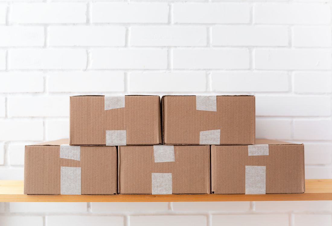 Neatly stacked plain kraft corrugated cartons with visible flute edges