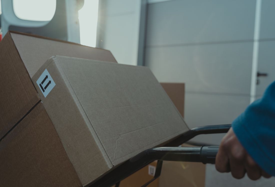 Folded wrap mailers and parcels collected on a logistics trolley for dispatch
