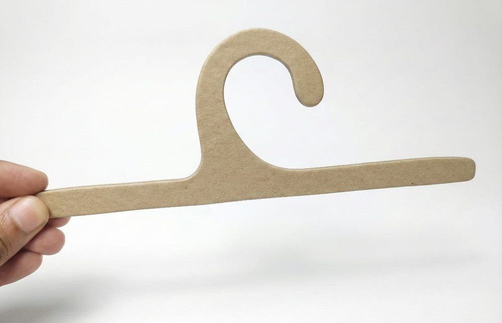 Kraft paper garment hanger with a die-cut hook held in hand — recyclable cardboard hanger by Padma Accessories